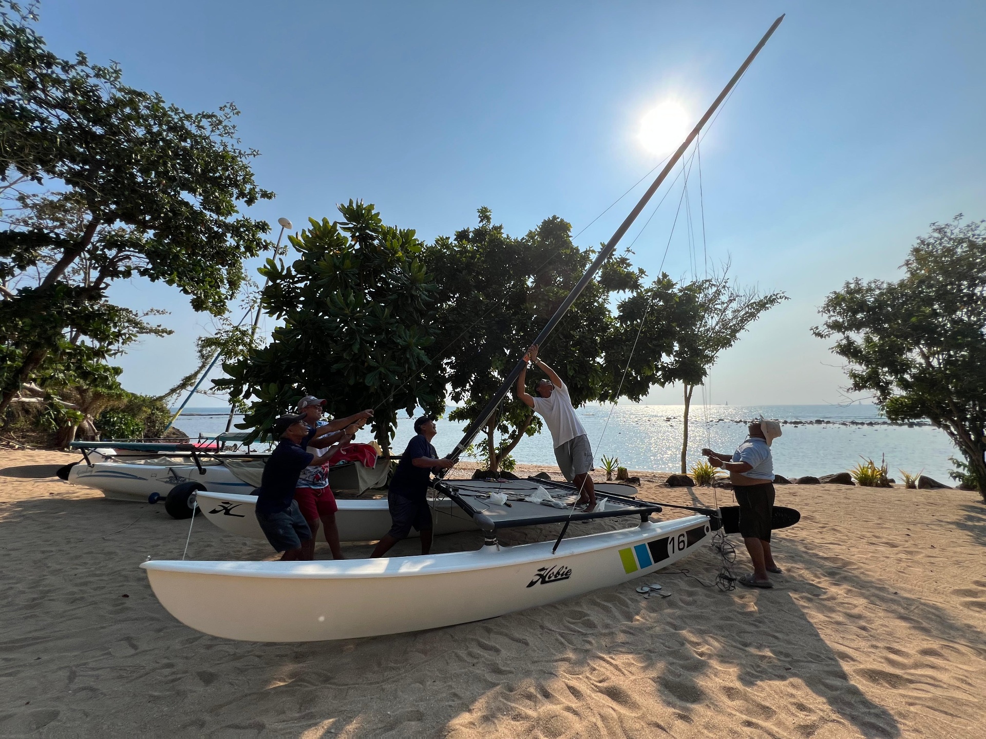The Subic Sailing crew rigging the mast at sunrise.